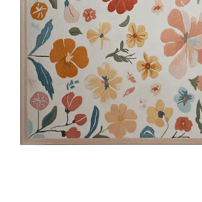 A vibrant hand-tufted wool area rug featuring an abstract floral pattern with bold colors like orange, yellow, and blue, set against a light background.