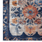 Close-up view of the Blossom Artistry Hand Knotted Rug showcasing intricate floral patterns in warm colors like orange and blue. This square area rug, inspired by Persian rugs, is perfect for adding elegance to a living room. Made of wool, it's an ideal large living room rug.