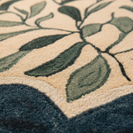 Close-up of a textured rug with green leaf patterns on a beige background
