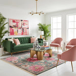Modern living room with green sofa, pink chairs, and a colorful pink rug.