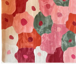 A vibrant Blossom Mosaic Hand Tufted Wool Rug, showcasing a colorful abstract floral design. This large area rug, perfect for a living room, features shades of red, pink, green, and orange. Ideal for those seeking a stylish wool rug in sizes like 8x10.