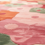 Close-up of a colorful floral-patterned rug with pink, green, and orange hues.