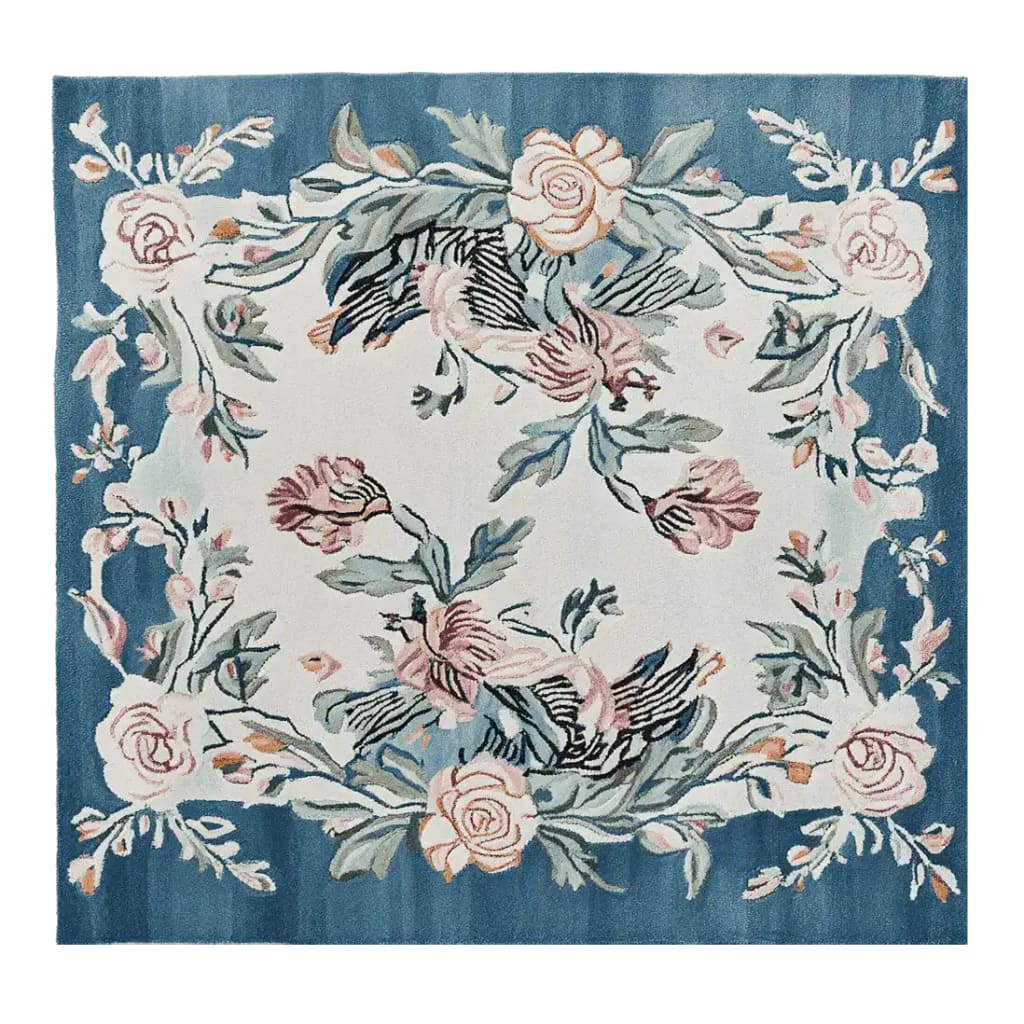 The Blossom Serenade Tapestry Hand Tufted Rug features a striking floral design with pink and peach blossoms on a woolen surface. This square area rug is perfect for adding elegance to any living room. The blue and white color scheme enhances the floral patterns, making it an ideal choice for those seeking stylish rugs for living rooms. Its size, resembling an 8x10 layout, makes it a versatile addition to any space.