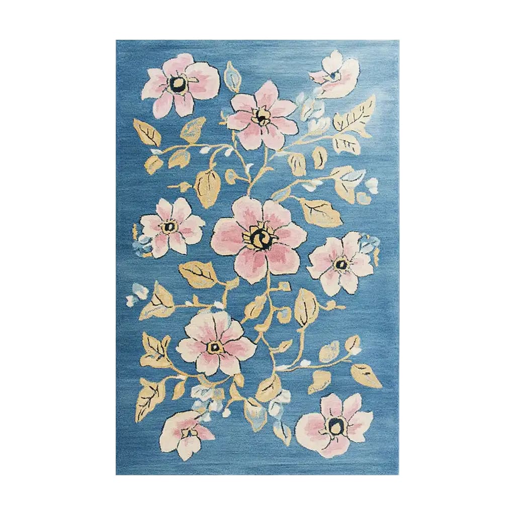 The Blossom Vine Tapestry Hand Tufted Wool Area Rug features an elegant floral design with pink blossoms and golden vines on a blue background, creating a vibrant and inviting look.