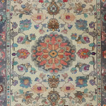 Blossom Vista Hand Knotted Area Rug featuring an intricate floral pattern reminiscent of Persian rugs. This vintage rug design showcases vibrant flowers in shades of red, blue, and beige, perfect for adding elegance to living room spaces.