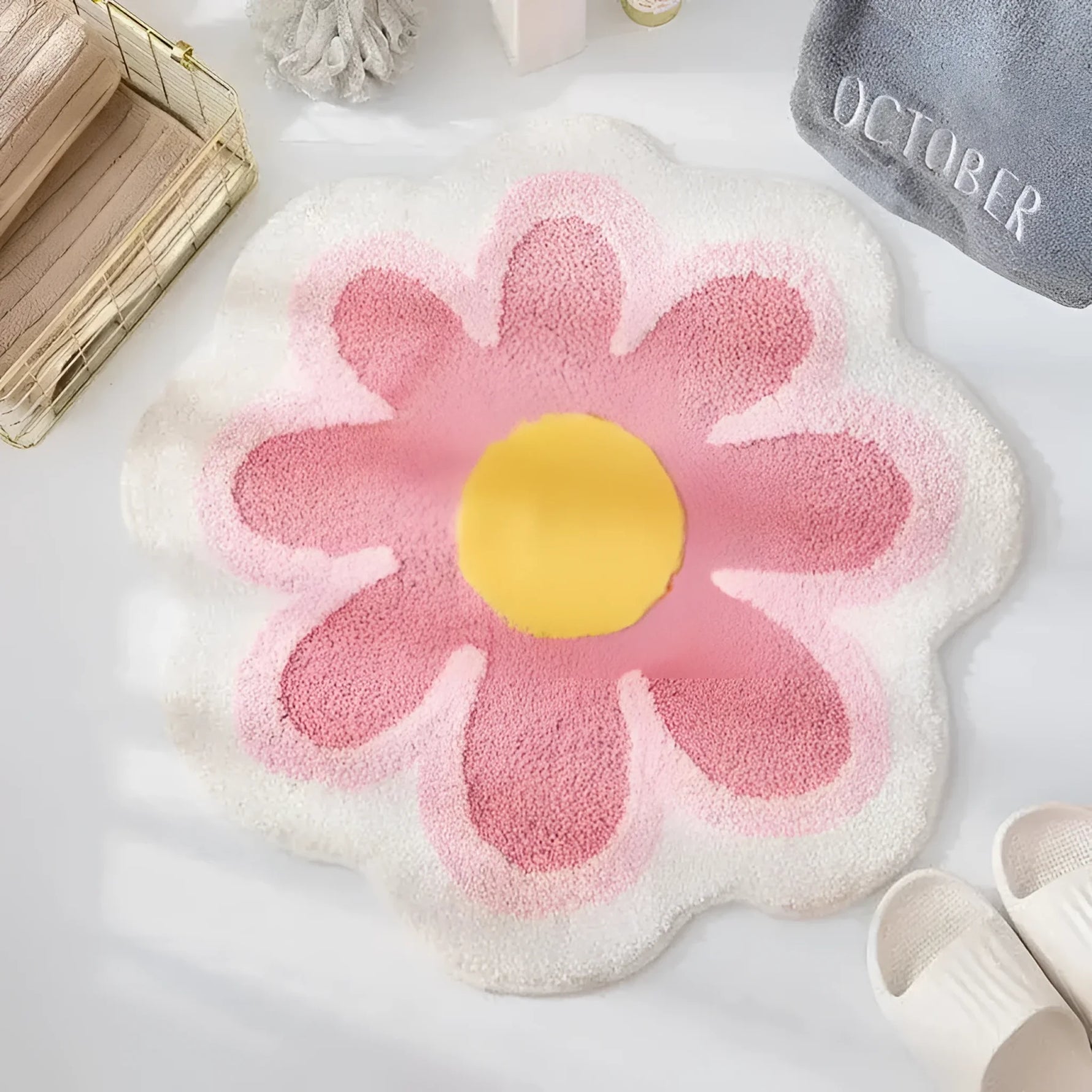 A charming area rug shaped like a blossoming flower in a bathroom setting. The rug features a vibrant yellow center with pink petals and a soft white outline, adding a lively touch to the decor.