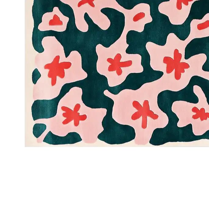 A vibrant area rug featuring an abstract floral pattern in bold red and soft pink against a deep teal background, showcasing a modern artistic design.