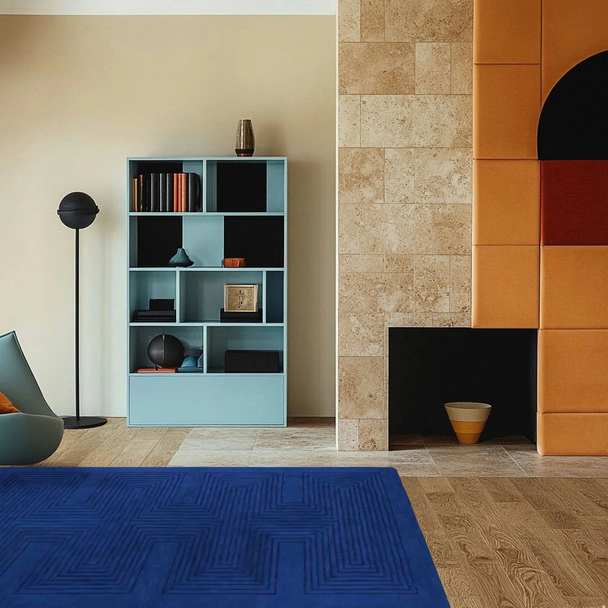 Modern living room with a blue rug, bookshelf, and colorful wall.