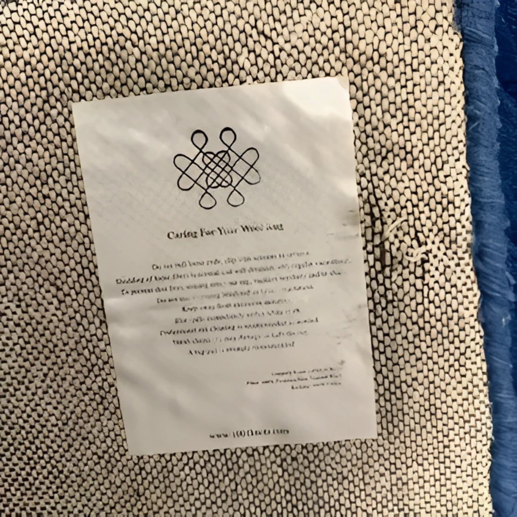 Close-up view of the back of the Blue Arctic Geo Modern Hand Tufted Wool Rug, highlighting the detailed weave and care instructions. Perfect choice for rugs for living room or dining room, this wool rug combines style and durability.