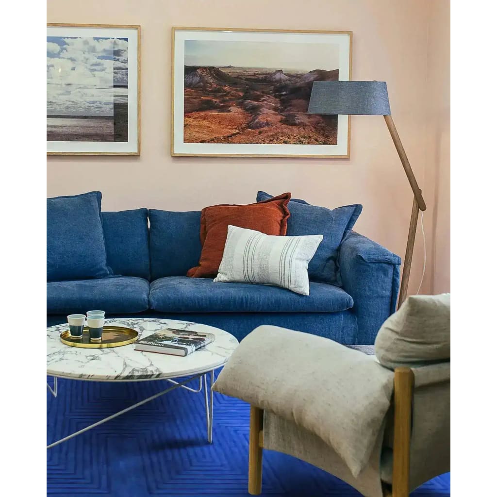 A stylish living room featuring a Blue Arctic Geo Modern Hand Tufted Wool Area Rug. The 8 x 10 ft rug adds a bold touch to the space, complementing the blue sofa and modern decor. Perfect for enhancing rugs for living rooms or dining room settings, this wool rug combines comfort and design seamlessly.