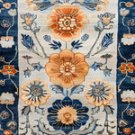 Close-up view of the Blue Blossom Edge Medium Hand Knotted Wool Rug showcasing its intricate floral design. This elegant area rug features vibrant orange and blue flowers against a soft background, perfect for adding a touch of Persian elegance to bedrooms. Ideal as a wool rug for bedrooms, it combines beauty and comfort, making it a standout piece among large area rugs and floral rugs.