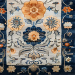 Close-up view of a Blue Blossom Edge Medium Hand Knotted Wool Rug, showcasing intricate Persian-inspired floral patterns in vibrant shades of blue, orange, and beige. This large area rug is perfect for adding a touch of elegance to any bedroom, making it an ideal choice for those seeking quality rugs for bedroom spaces.