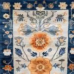 A close-up view of a Blue Blossom Edge Medium Hand Knotted Wool Rug showcasing intricate floral patterns. This elegant area rug features vibrant blue and orange floral designs, perfect for adding a touch of Persian-inspired style to any bedroom. Ideal as a bedroom area rug, this wool rug offers a luxurious feel and a sophisticated look.