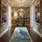 Decorative hallway with floral wallpaper, a console table, and a peacock rug.