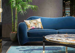 Stylish living room featuring a Blue Peacock Floral Hand Tufted Area Rug. The wool rug adds a touch of elegance and comfort, complementing the plush blue sofa and vibrant decor. Perfect for enhancing bedroom spaces with quality bedroom rugs.