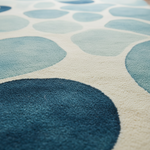 Luxurious living room with blue sofas, yellow chairs, and a patterned rug.
