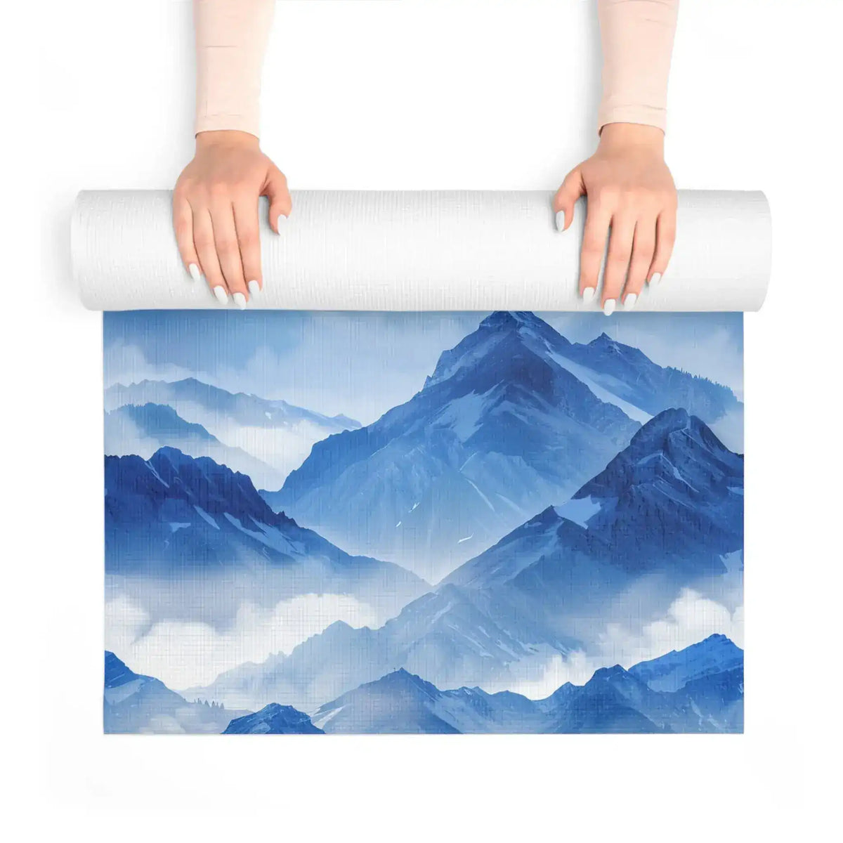 Hands unrolling the blue watercolor mountain yoga mat over its painted peaks