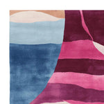 Vibrant and contemporary Blushing Coastline Drift hand-tufted area rug featuring an abstract design with rich shades of blue and pink. Ideal for adding a modern touch to living room spaces, this wool rug combines style and comfort, making it a perfect choice for those seeking unique rugs for living room decor.