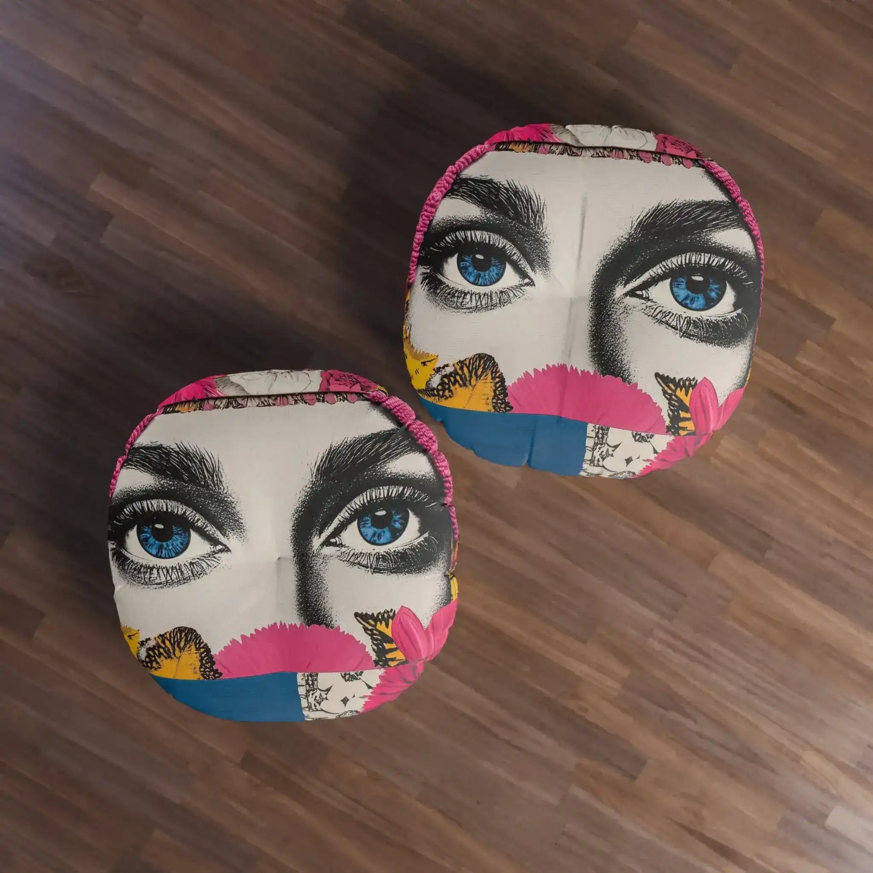 Two Bold Floral Portrait Floor Pillows from above on dark wood floor showing colorful blue eyes floral collage pattern