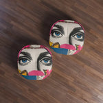 Two Bold Floral Portrait Floor Pillows overhead on dark wood floor showing pop-art blue eyes floral collage design
