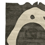 Close-up view of the Bone Ring Ritual Hand Tufted Area Rug, showcasing its unique abstract design in black and white tones. Perfect for adding a contemporary touch to living room area rugs, this wool rug combines style and comfort.