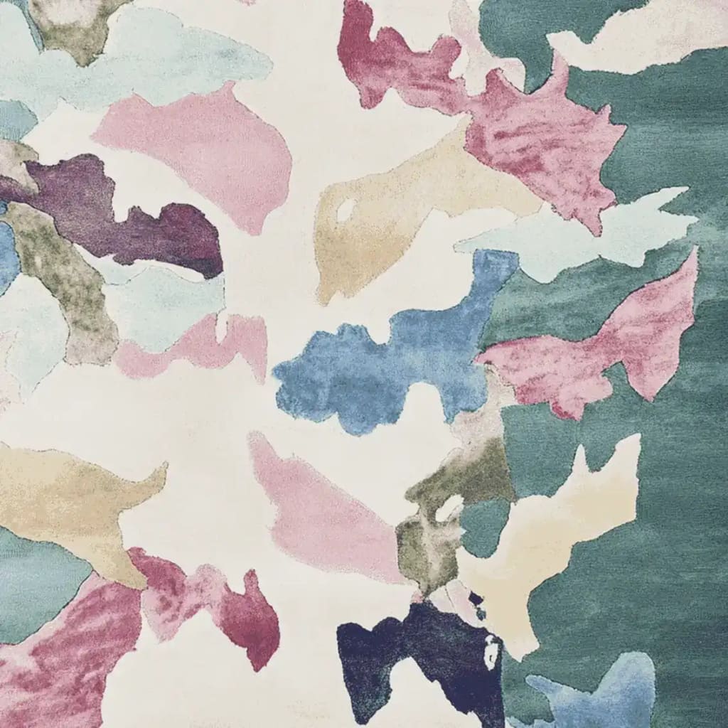 A vibrant area rug featuring an abstract design with splashes of pink, blue, green, and beige hues. Perfect for contemporary living rooms, this wool rug adds a touch of artistic flair and comfort.