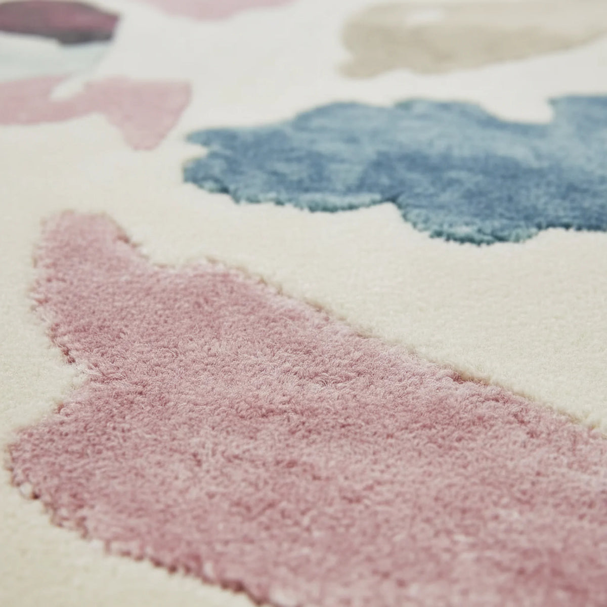 Close-up of a soft, textured rug with pink, blue, and white colors.