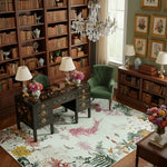 Stylish living room with bookshelves, a pink floral fish rug, a desk, and decorative elements.