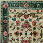 Close-up view of the Botanical Bliss Medium Hand Knotted Wool Rug, showcasing intricate floral patterns in vibrant colors. This Persian-style vintage rug, perfect for dining room carpets or as a centerpiece in living room decor, highlights the elegance of wool rugs with its exquisite design.