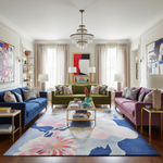 Living room with colorful furniture and a floral rug
