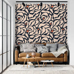 Botanical extravaganza wallpaper behind tan leather sofa; cream and navy abstract oversized leaves with orange accents