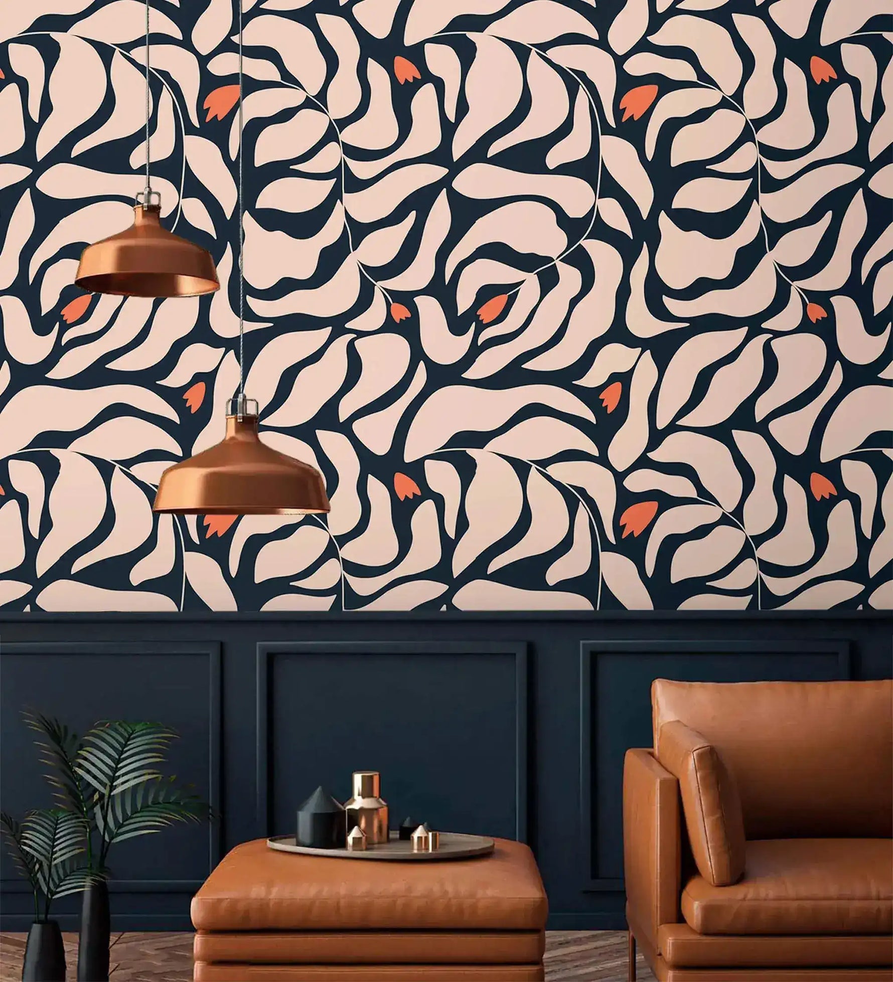Botanical extravaganza wallpaper above navy panels with tan leather armchair, ottoman, and pair of copper pendant lights