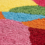 Close-up of a colorful geometric-patterned rug with vibrant colors.