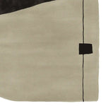 Close-up view of a contemporary wool area rug featuring a minimalist design with a beige background and abstract black lines, perfect for enhancing living room decor.