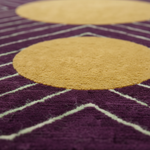 Close-up of a purple and yellow geometric patterned rug