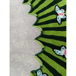 Close-up of the Butterflies over Flower Hand Tufted Wool Rug in green, showcasing a vibrant design with butterflies and a scalloped edge. Perfect for adding a touch of nature to your office or large living room. This area rug features a durable wool texture, ideal for living room decor.