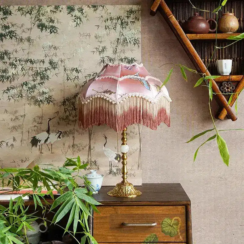 pink dome butterfly lampshade with long fringe tassels on ornate brass base styled in botanical room