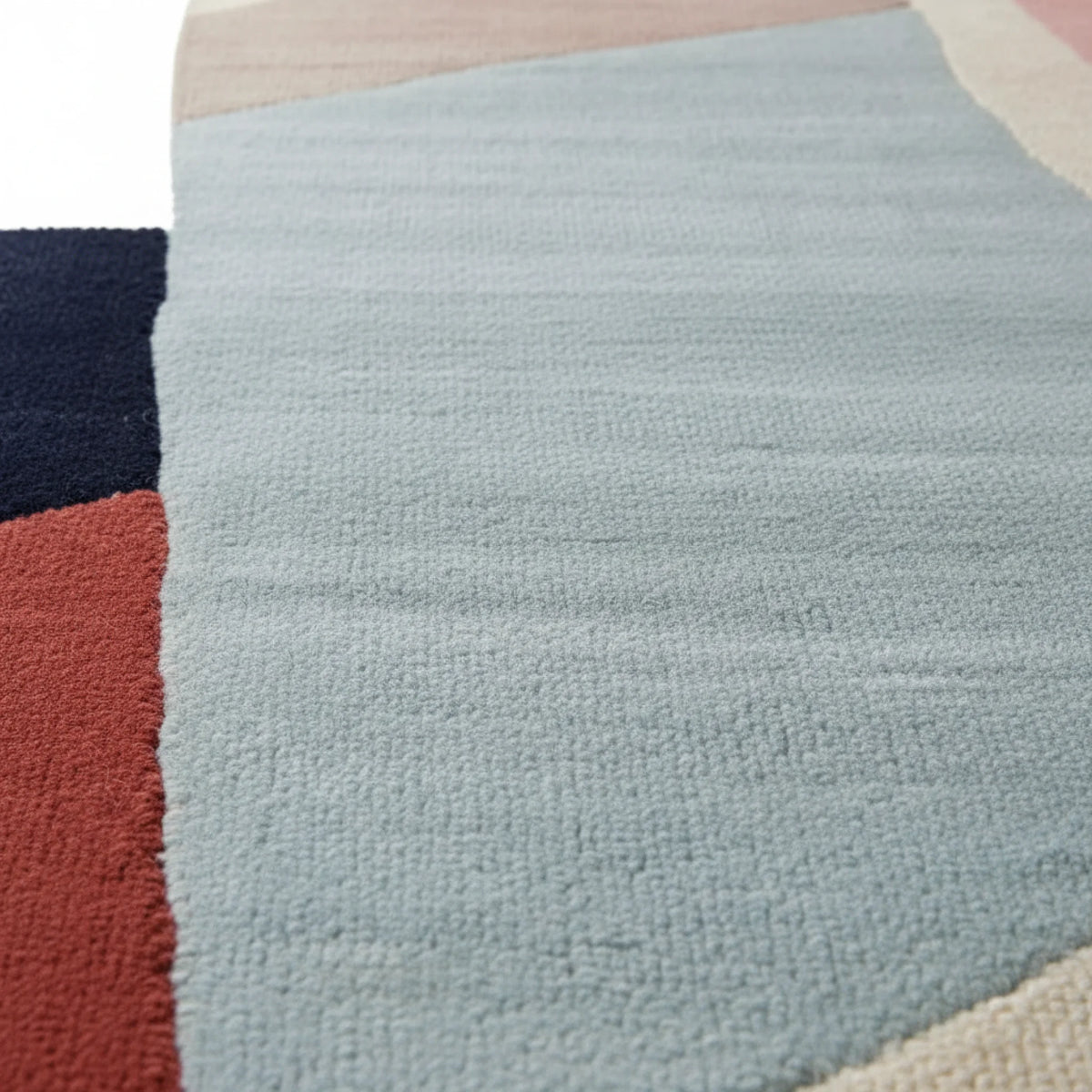 Close-up of a textured rug with a geometric pattern on a white background