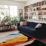 calming colors hand knotted wool rug with abstract color blocks in cream blue yellow orange black under navy sofa