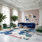 Modern living room with a blue sofa, green chairs, a contemporary wool rug, and decorative wall art.