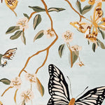 A beautifully designed area rug featuring a delicate hand-tufted pattern with butterflies and floral branches. This wool rug is perfect for adding a touch of nature-inspired elegance to living room spaces, making it an ideal choice for those seeking stylish living room area rugs.