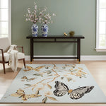 Decorative rug with butterfly and floral design in a room with a console table and chairs.
