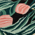 Close-up of a textured surface with pink floral patterns and green leaves.