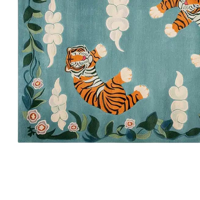 A beautifully crafted hand-tufted wool area rug featuring a vibrant abstract tiger design. The rug displays a playful tiger amidst floral patterns on a soothing blue background, perfect for adding a touch of elegance and whimsy to any room.