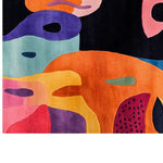 A vibrant area rug with an abstract, colorful design featuring bold splashes of orange, purple, blue, and pink hues. The hand-tufted wool rug showcases a whimsical pattern, adding a playful touch to any room decor.