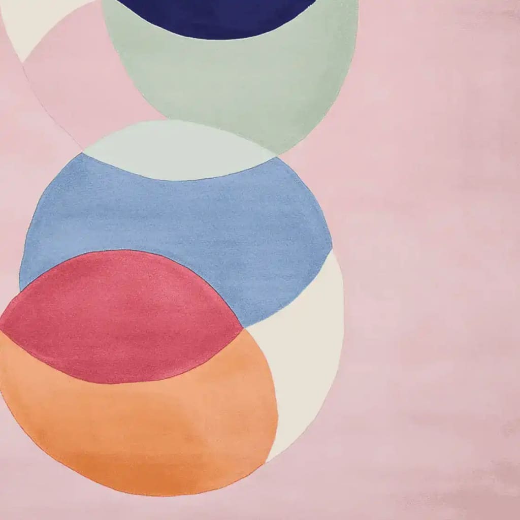 A close-up view of the Chakra Circle Dance Hand Tufted Area Rug, showcasing its vibrant, contemporary design. The wool rug features an abstract pattern with overlapping circles in shades of pink, blue, green, and orange, ideal for adding a modern touch to living room spaces. This square area rug is perfect for those seeking unique area rugs for living room decor.