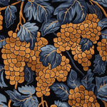 A close-up of the Chateau Vines Hand Tufted Rug, showcasing a vibrant pattern of orange grapes and blue leaves against a dark background. This area rug is perfect for adding a vintage touch to any living space. Ideal for living room rugs 8x10, this wool rug combines elegance and durability, making it a standout piece among large living room rugs.