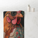 Chic Renaissance Chicken Bath Towel draped over white bathroom counter showing rooster in jeweled sunglasses and floral jacket with soap dispensers in background
