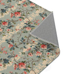 Folded corner of chinoiserie charm rug revealing gray non-slip backing and whipstitched edge