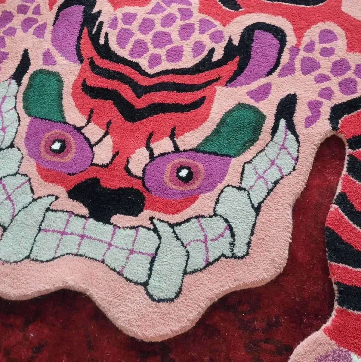 Close-up view of a Chinoiserie Pink Tibetan Tiger Tufted Wool Rug, showcasing its vibrant abstract tiger design. Perfect as a wool rug to add a unique touch to living room area rugs, enhancing large living room decor.